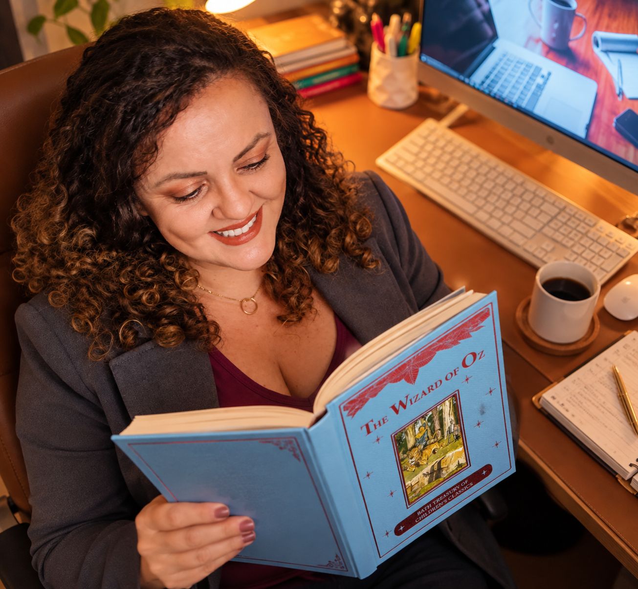 Marcela lendo um livro em inglês na sua mesa de trabalho